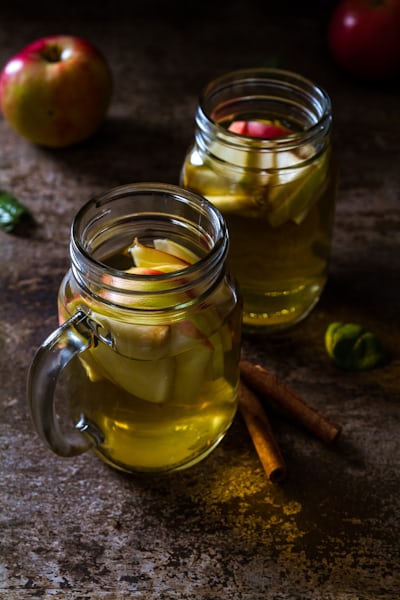 Glasses of cider with apple slices and cinnamon